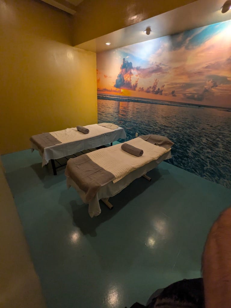 Cabina doble de masajes en pareja con mural de atardecer en el mar en Colonia Dávila Tijuana